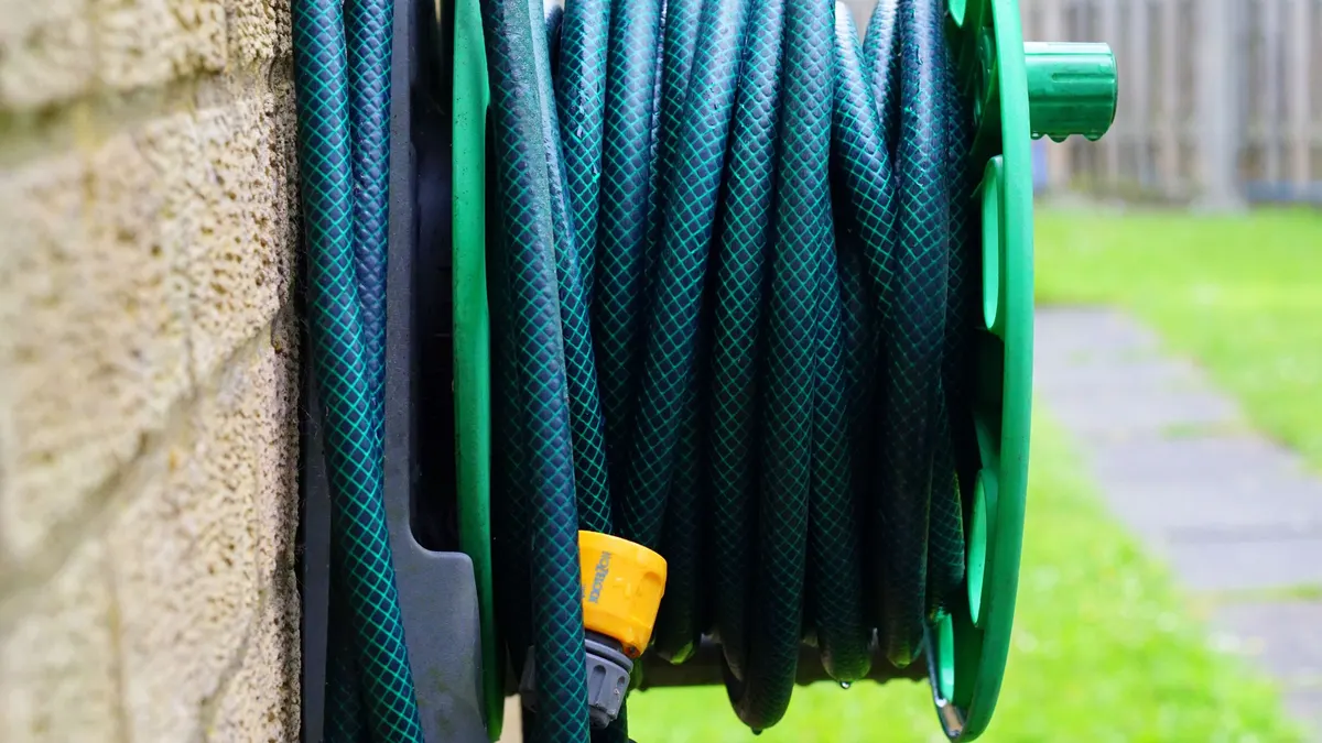 Green hose coiled on a wall-mounted reel