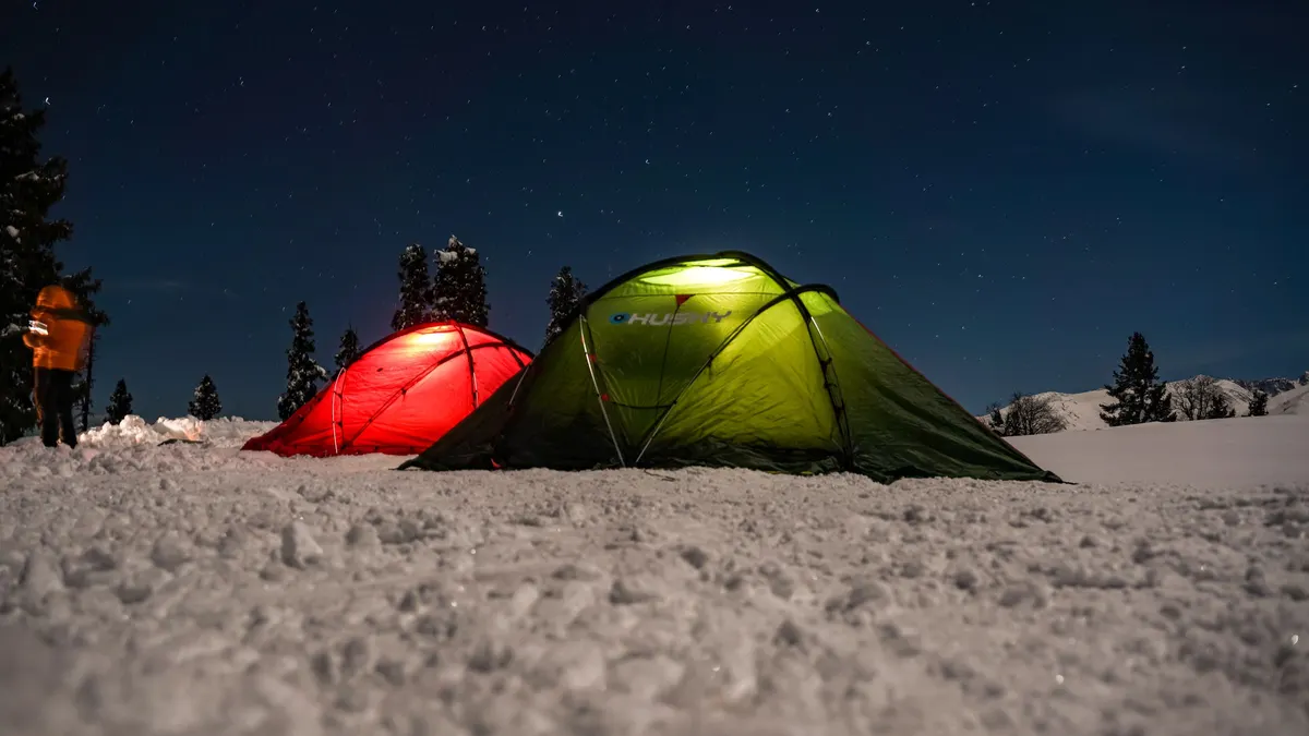 Tents glowing with interior lights at a campsite after dark