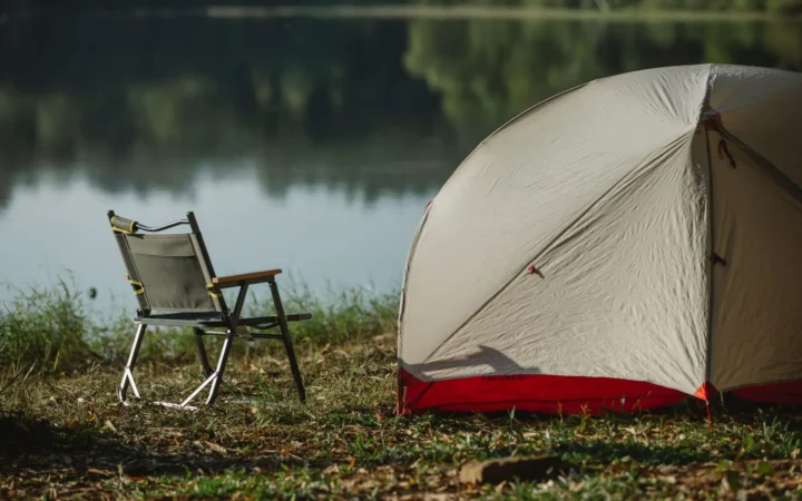Lakeside tent campsite with a camp chair, the kind of off-grid site where a portable power station earns its keep