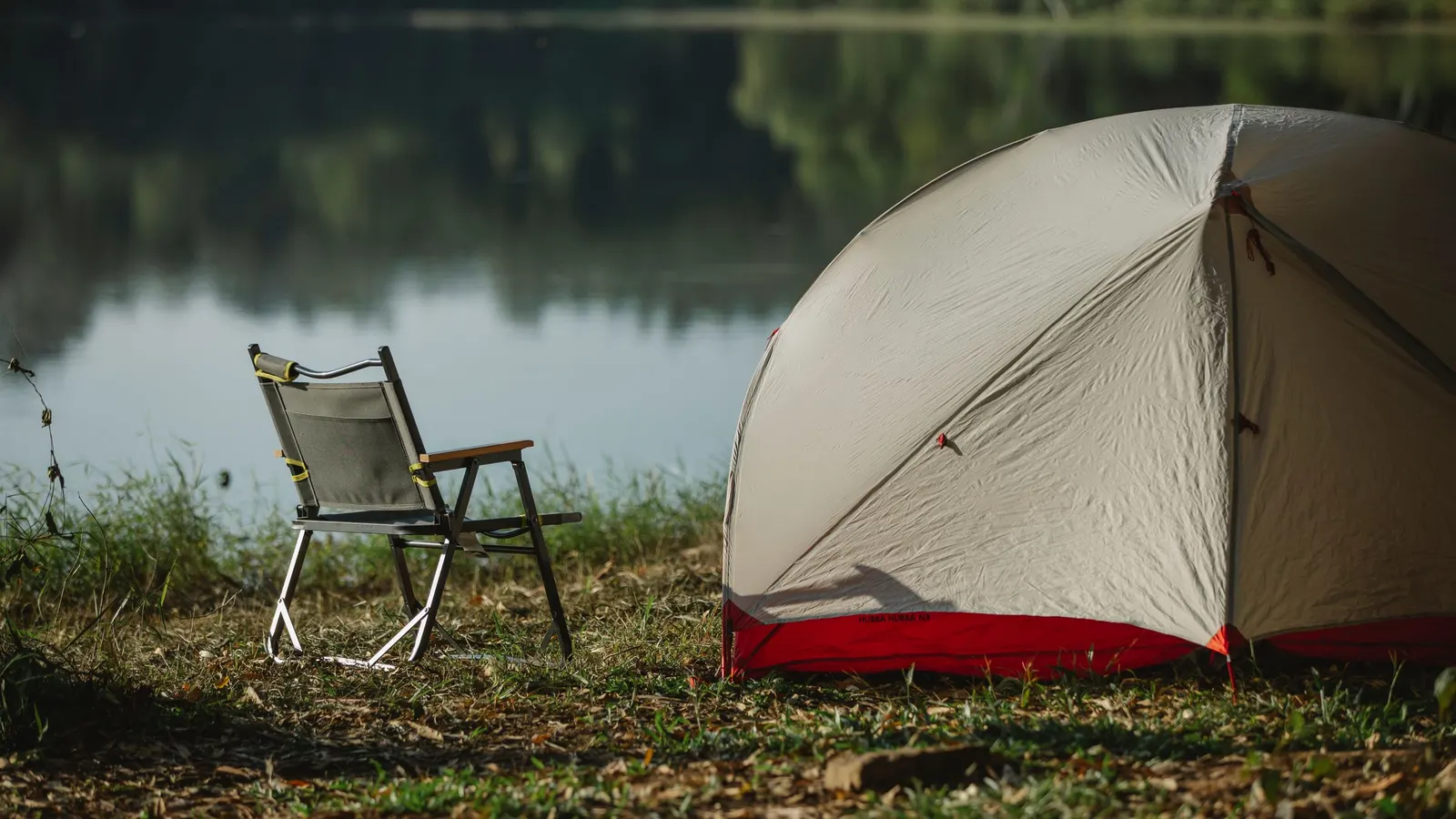 Lakeside tent campsite with a camp chair, the kind of off-grid site where a portable power station earns its keep