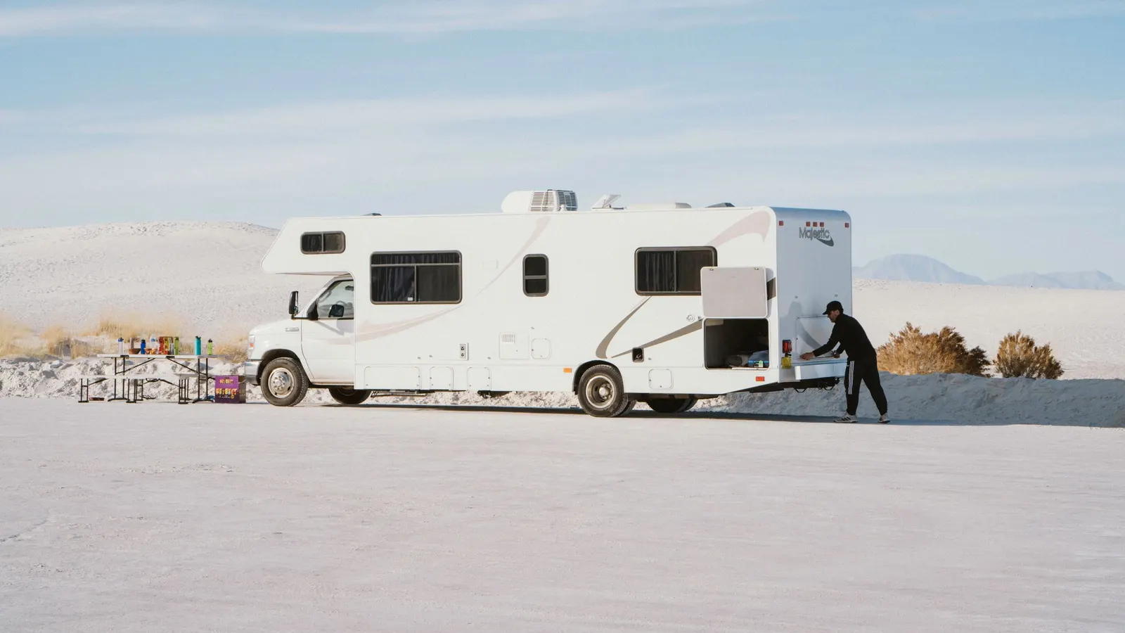 Class C motorhome parked in bright sun on an open desert flat