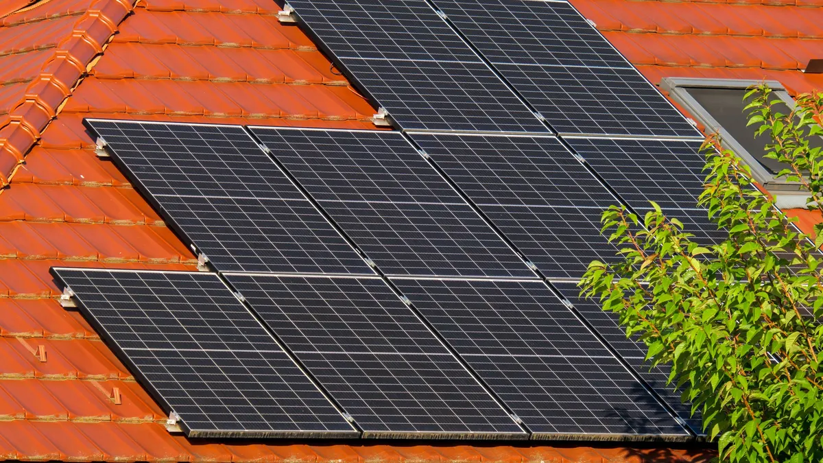 Rows of dark solar panels mounted on a tiled roof