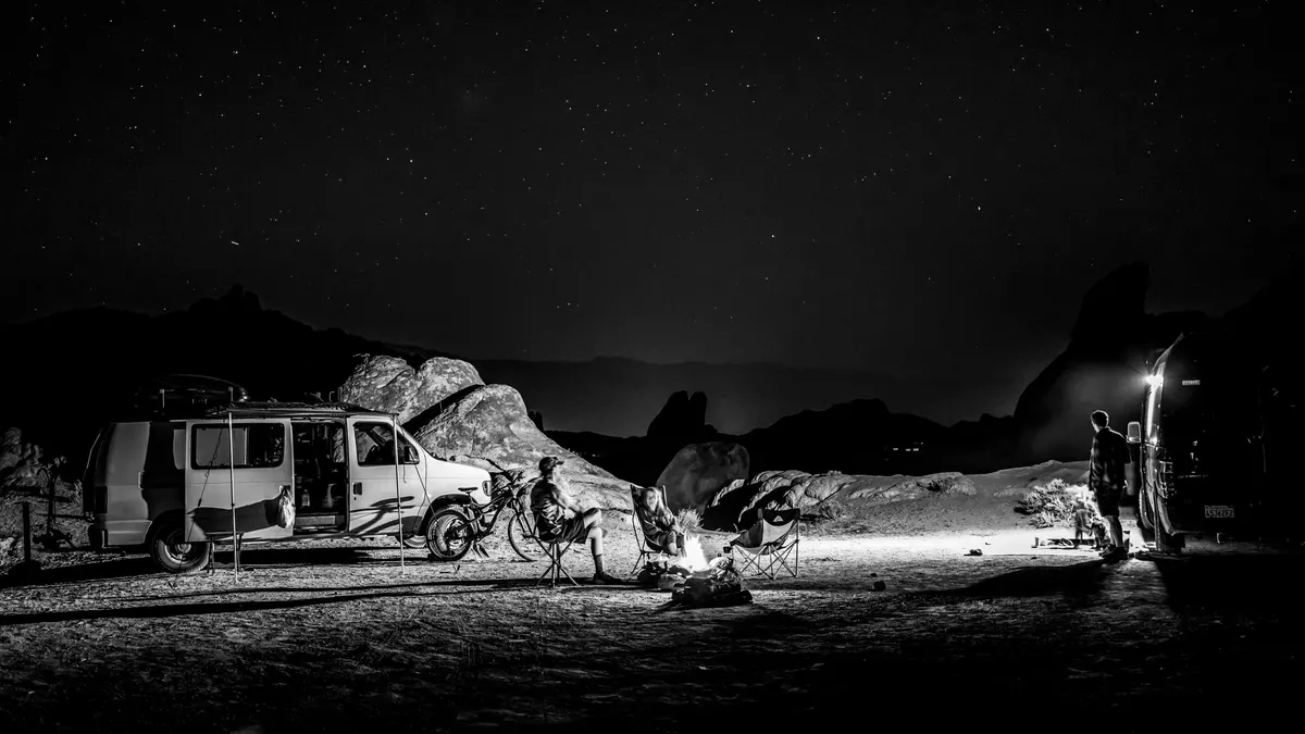 Camper vans parked in the desert at night under a clear sky