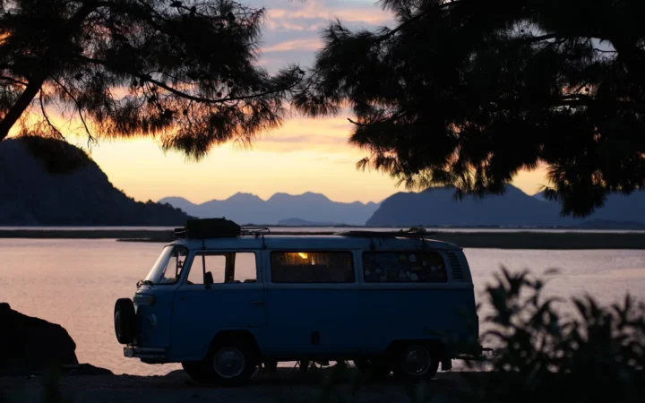 Camper van parked by a lake at sunset, the kind of free or low-cost stay that shapes the cost of full-time RVing