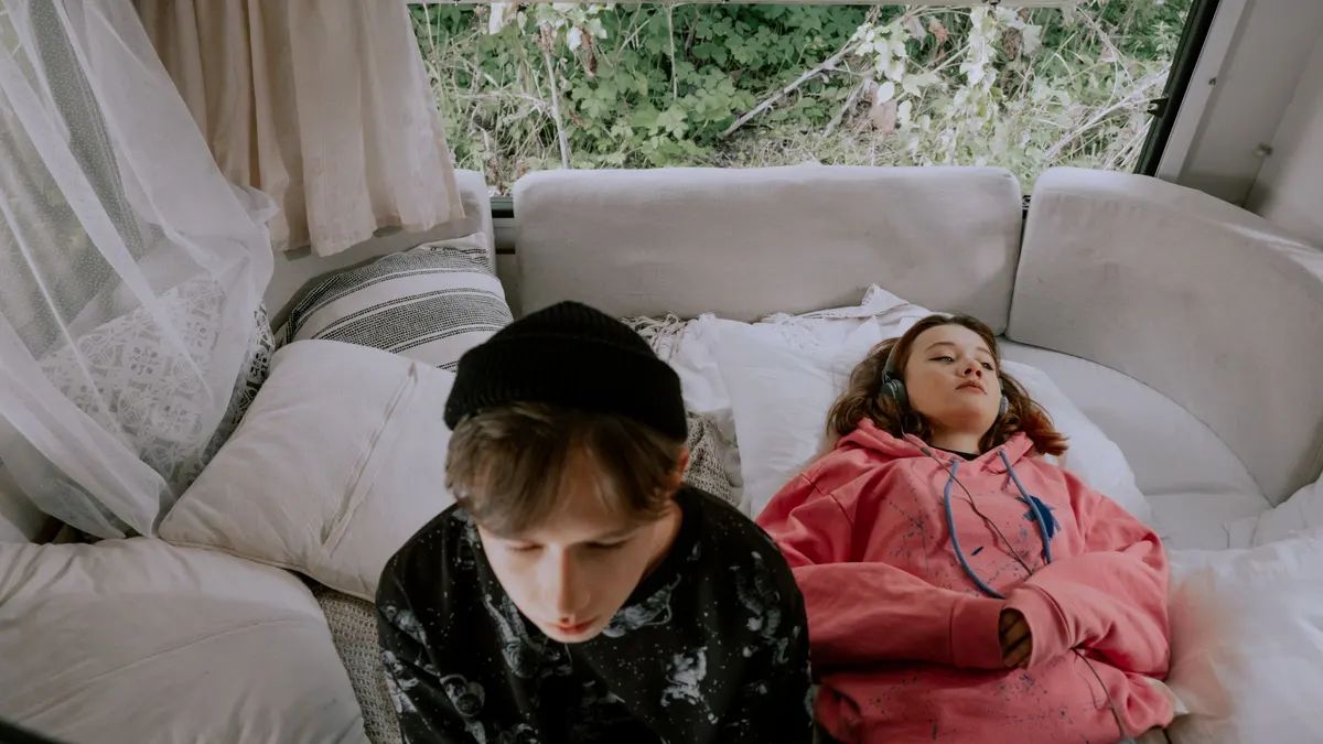Two people relaxing on a bed inside a camper van
