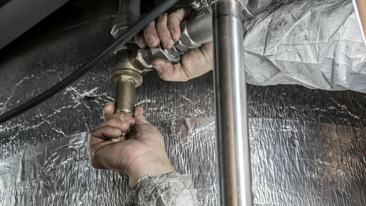 Hand turning a valve on a metal pipe