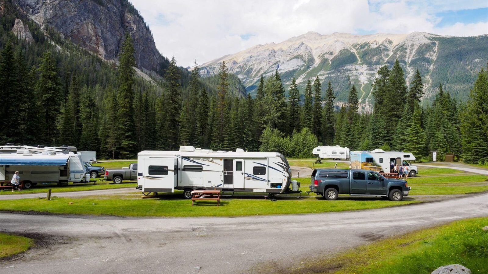Towable RVs parked with pickup trucks at a mountain campground