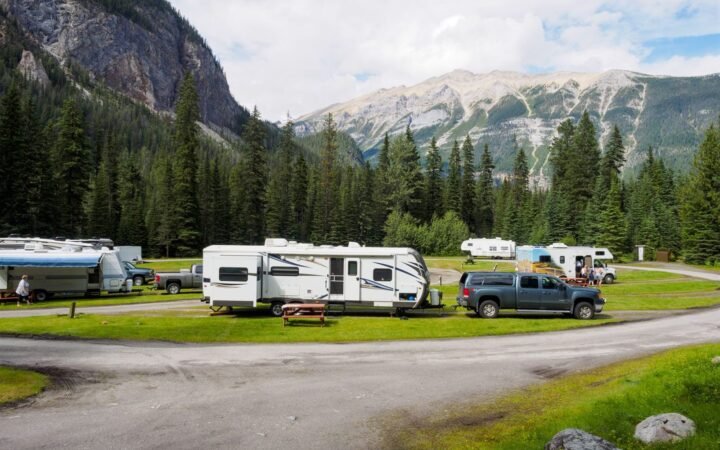 Towable RVs parked with pickup trucks at a mountain campground