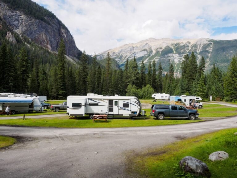 Towable RVs parked with pickup trucks at a mountain campground