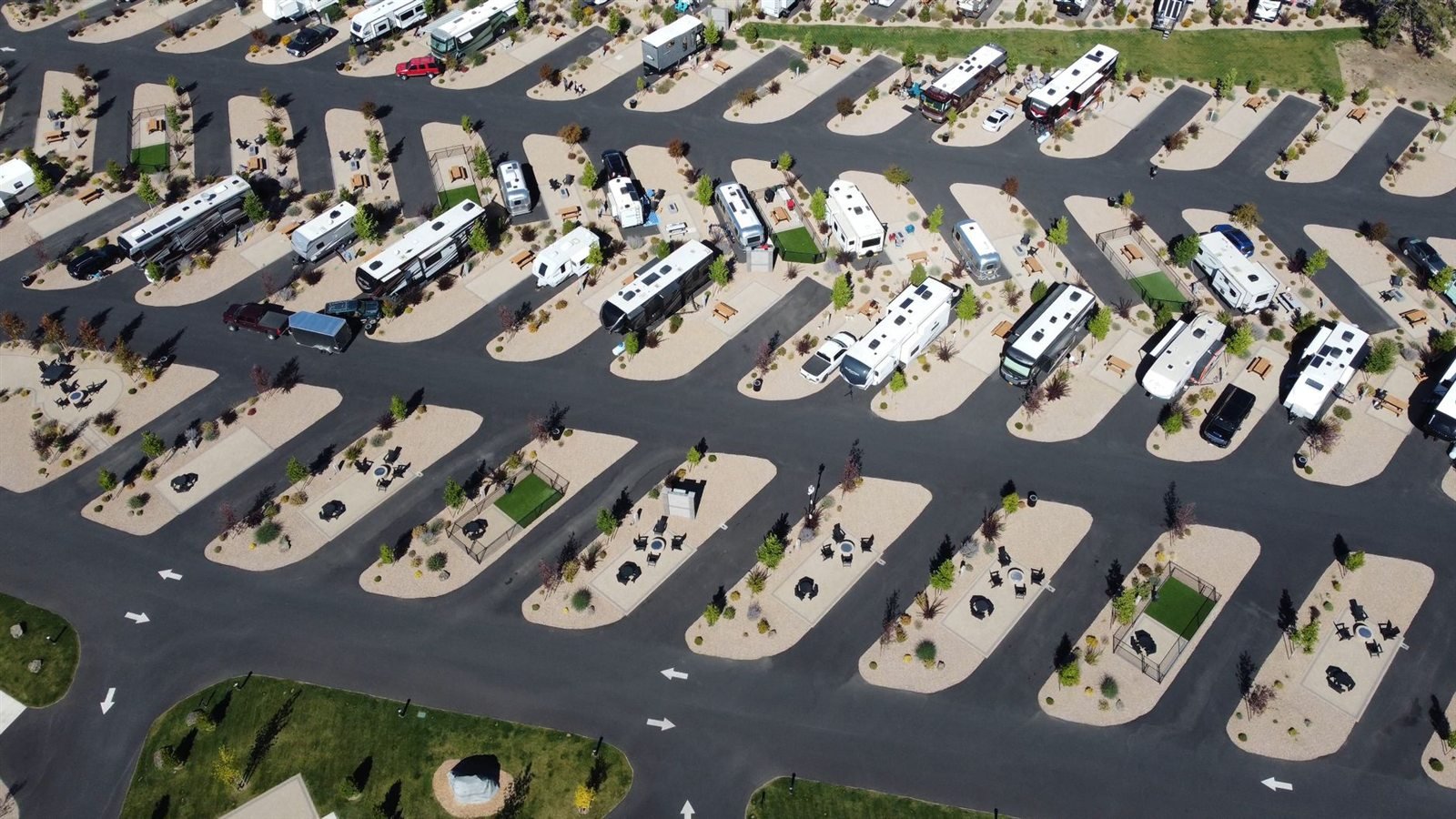 An aerial view of rows of RVs parked in a large campground