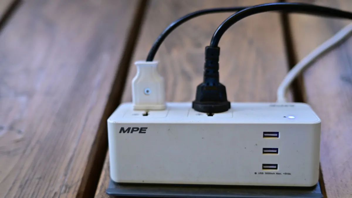 Plugs connected to a power strip on a wooden table