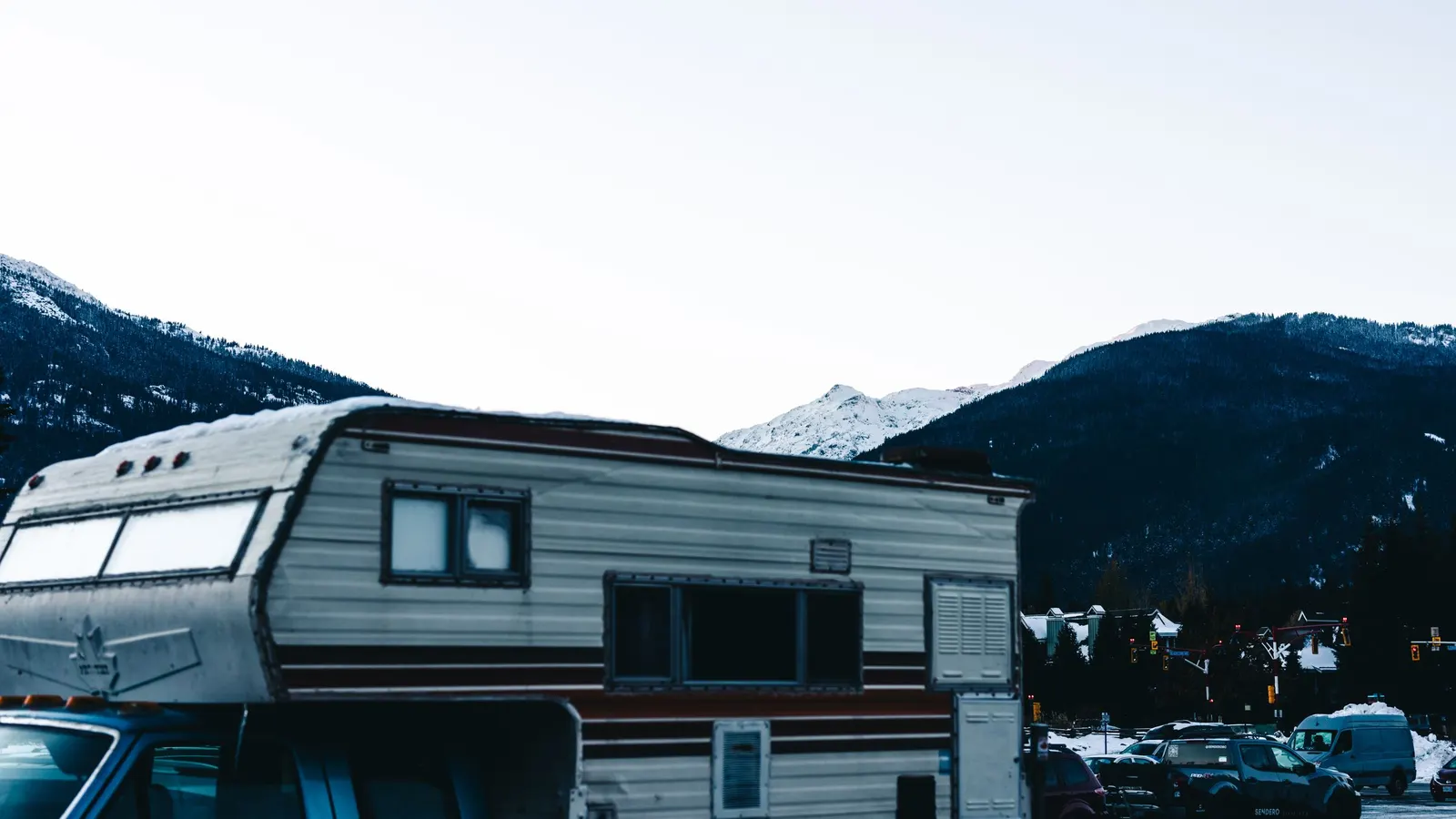 Travel trailer parked with snowy mountains behind