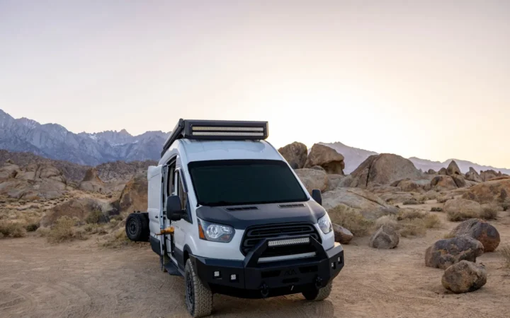 Camper van parked among desert boulders