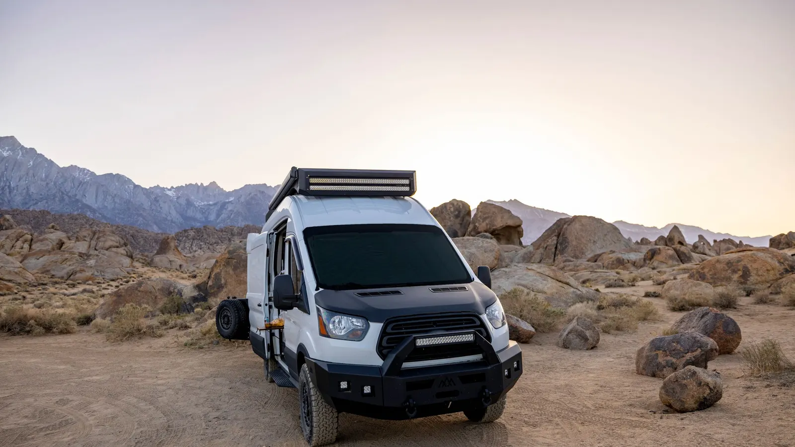 Camper van parked among desert boulders