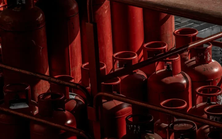 Rows of red propane cylinders stored upright in a rack